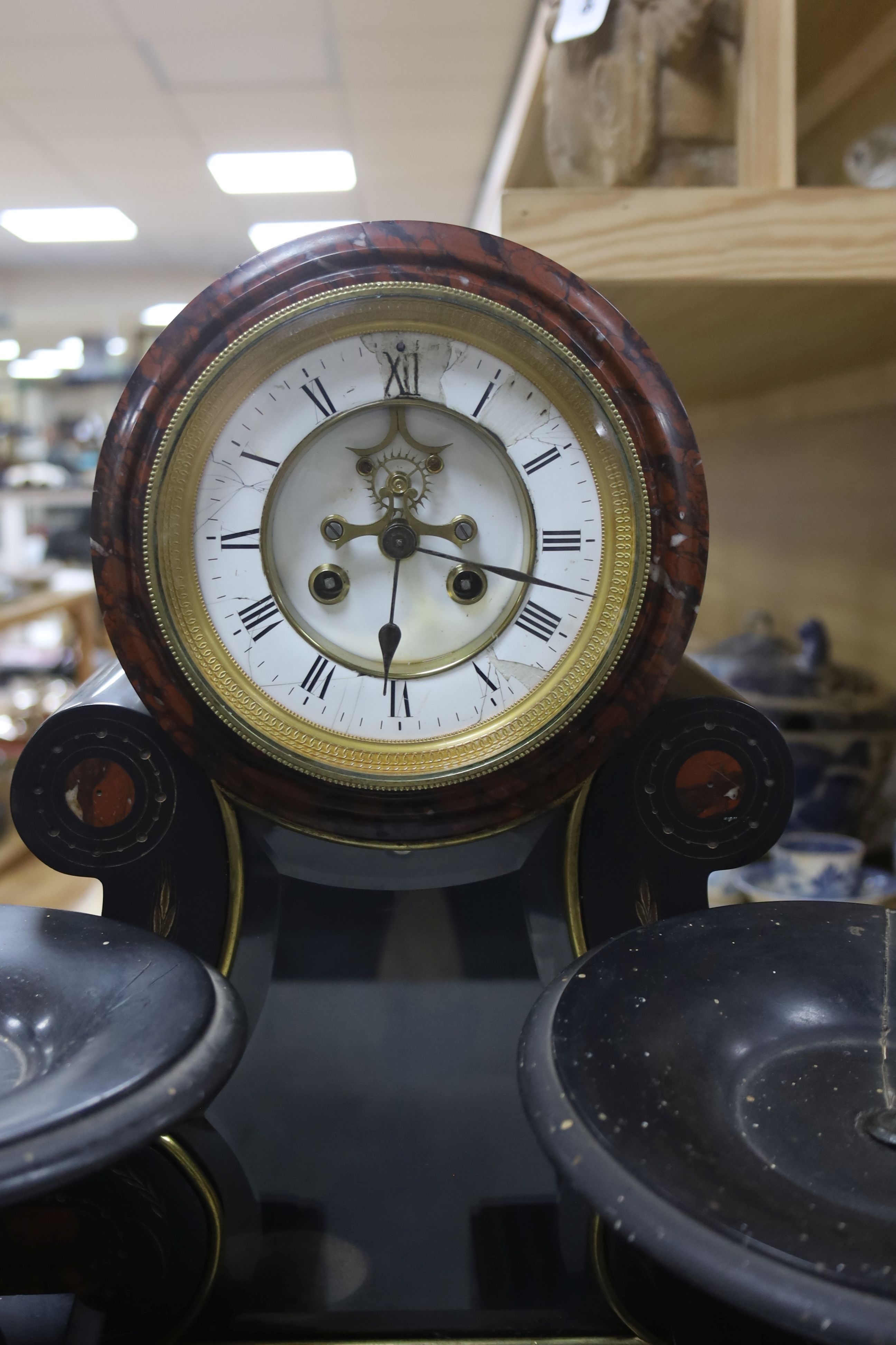 A 19th century Victorian slate clock garniture, the movement with visible Brocot escapement with key and pendulum (af), clock 49cm high